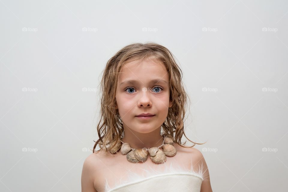 Little girl wearing a sea shell necklace.