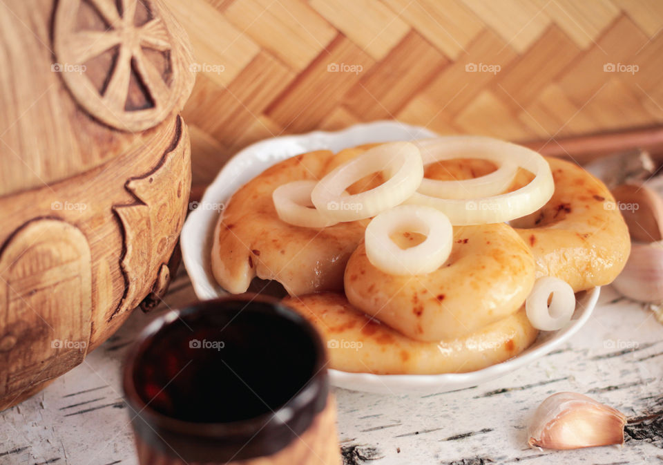 Pickled milk mushrooms with onion rings in white plate