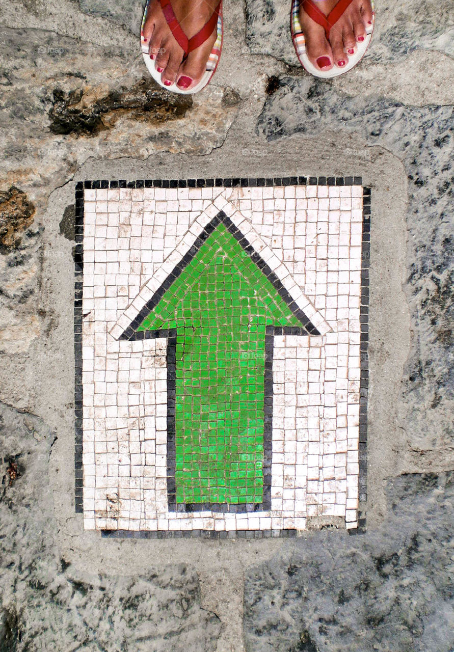 Directional green arrow sign on the ground