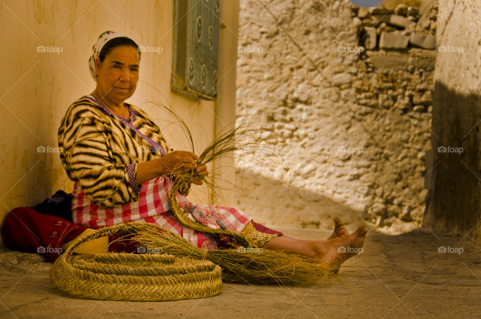 Woman making a basket in the street