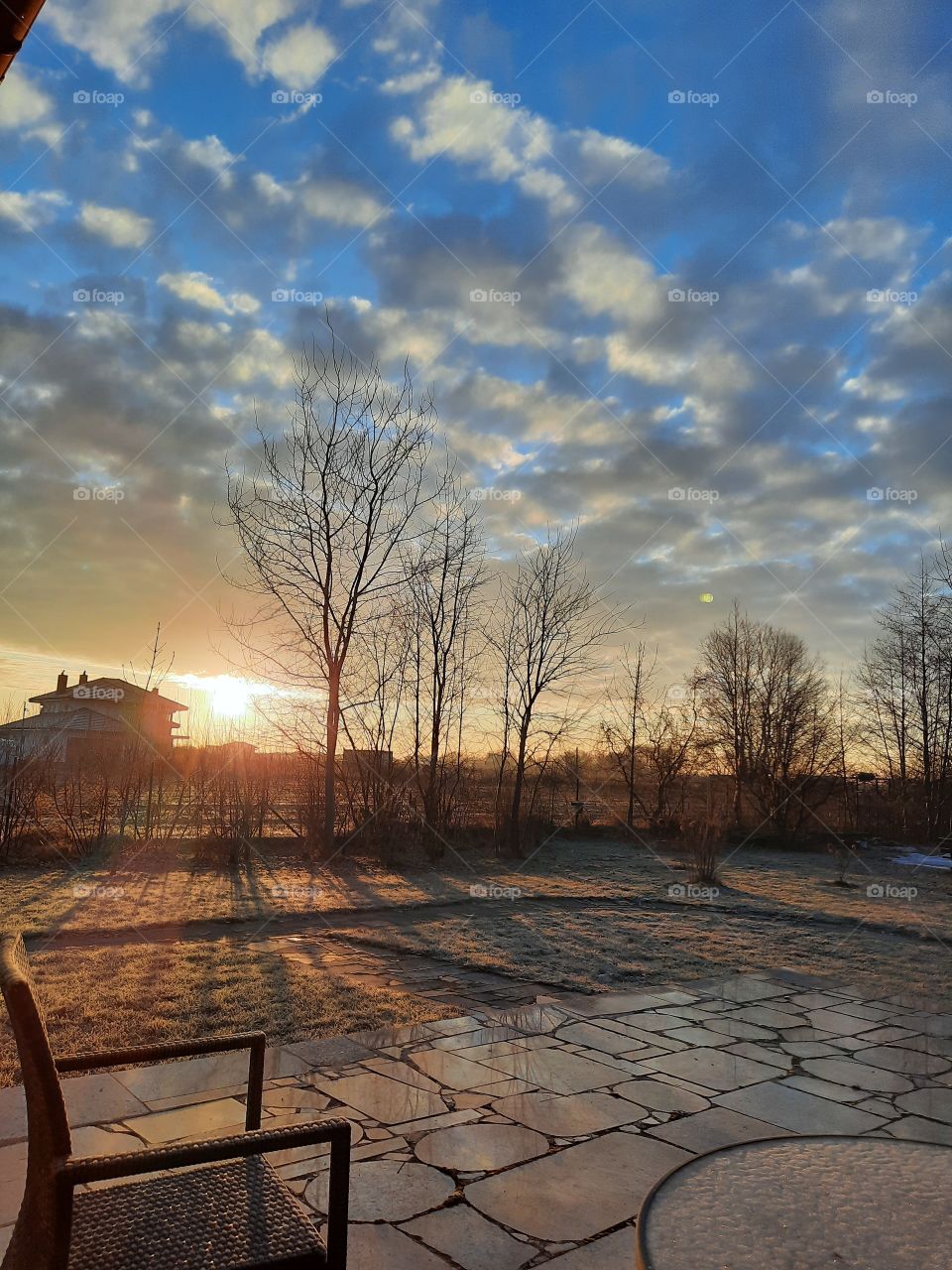 low sun after sunrise - orange sunshine long shadows  and reflections of sky on terrace