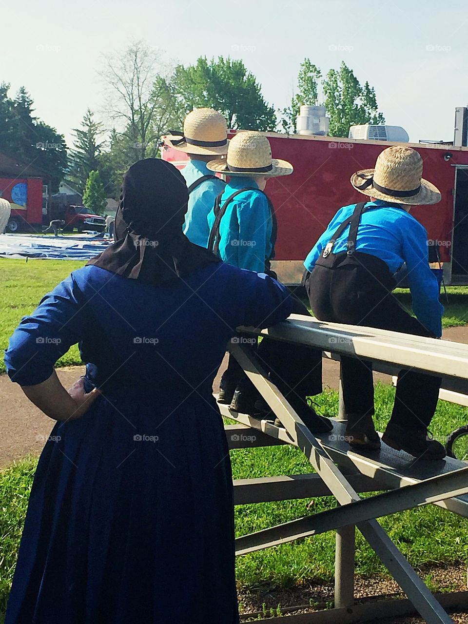 An Amish family watching a circus tent being assembled. 