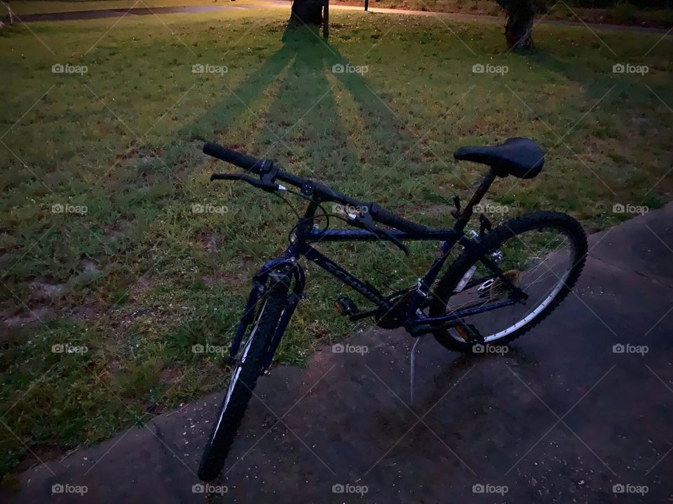 A Lonely Bicycle At Night Against Forgotten But Seen With The Street Light Standing.