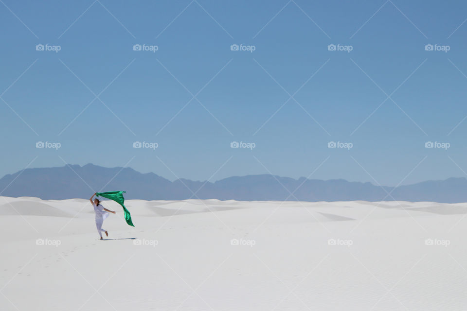 Woman holding a scarf and blowing in the wind