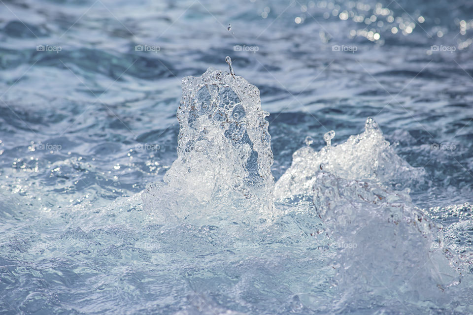 The blue water waves by wind and sunlight reflecting surface