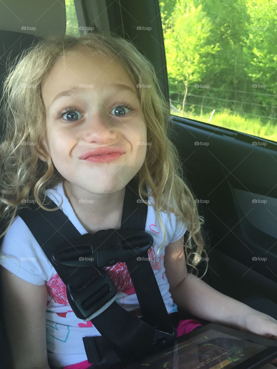 My goofy little daughter making faces in her car seat. 