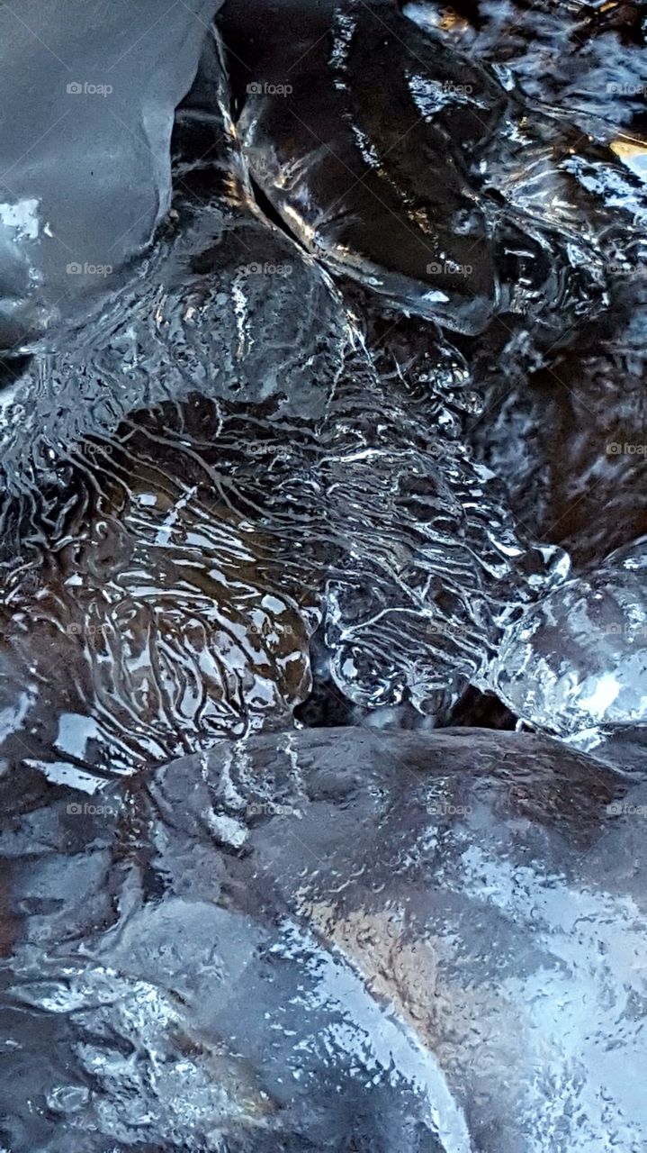 Ice trapped stream creates a natural sculpture. Water coursing over the stream bed produces a precise pattern.