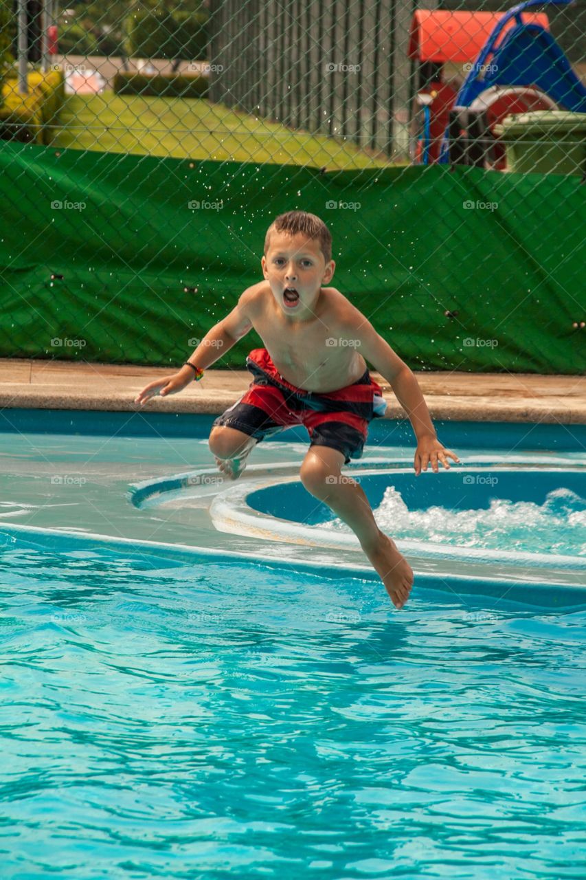 My little boy acting silly while jumping into the pool