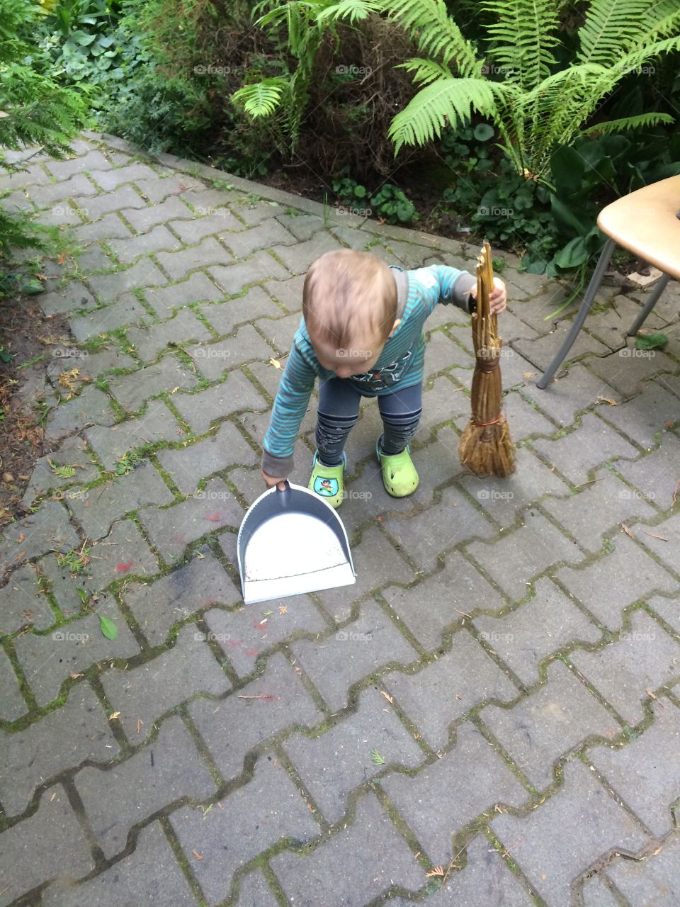Little helper. 1 year boy is helping to clean the yard