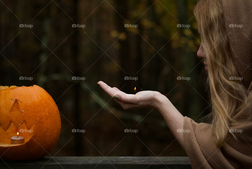 Igniting a Pumpkin’s soul; Woman holding a small flame next to 11 year old’s first, by himself, pumpkin carving 