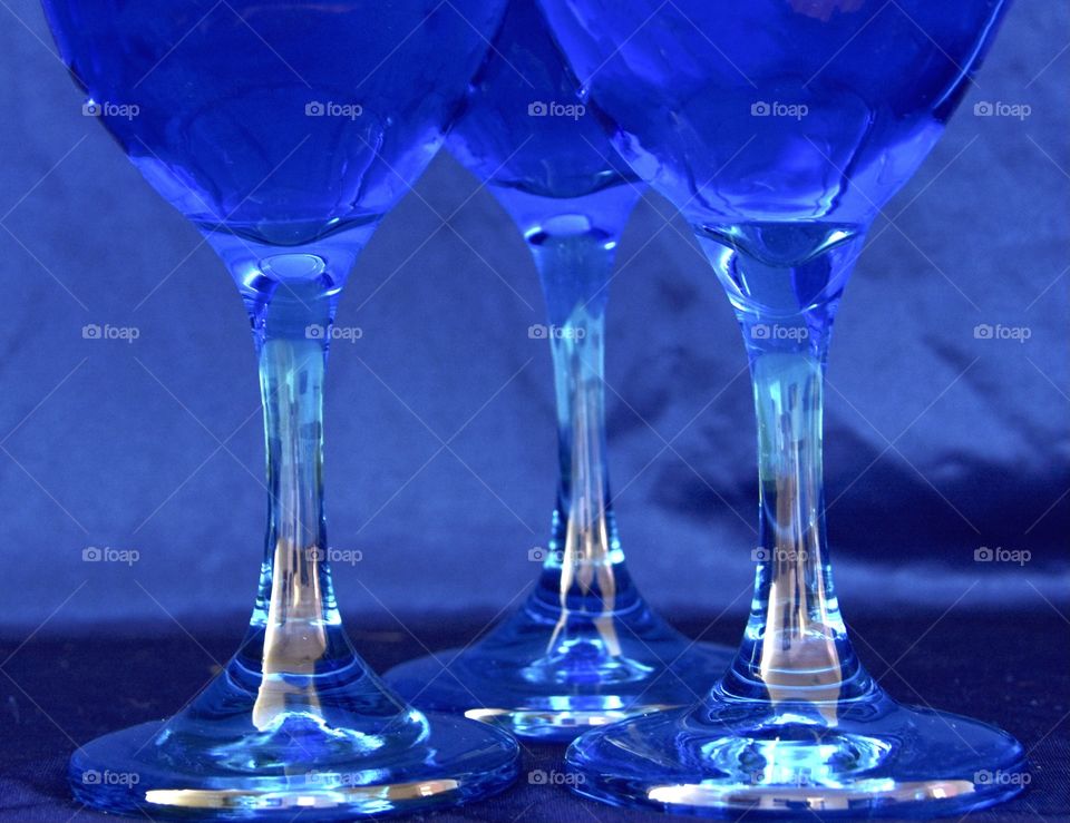 Three wine glasses with blue background and blue drink