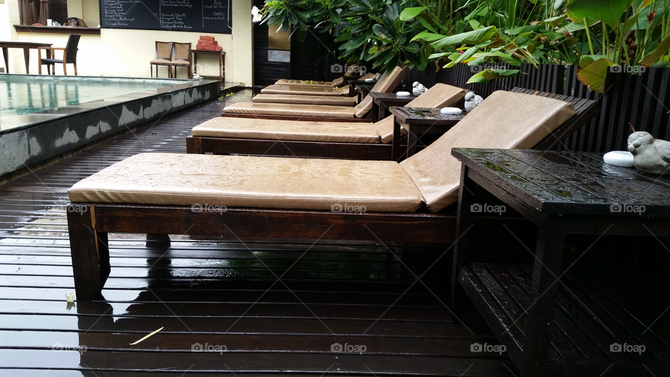 Poolside after the rain. The poolside furniture at the Praya Palazo after the rain rolls through in Bangkok