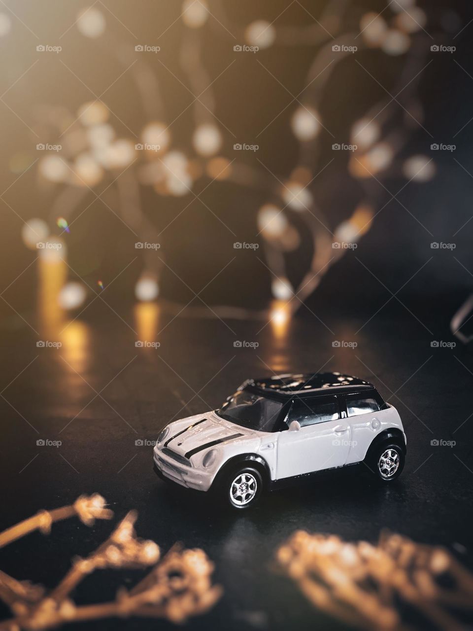 White miniature car with bokeh background.
