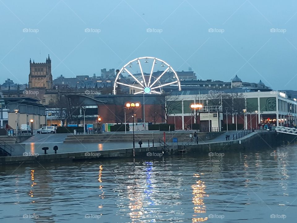 Bristol floating harbour at dusk with ferris wheel lit up