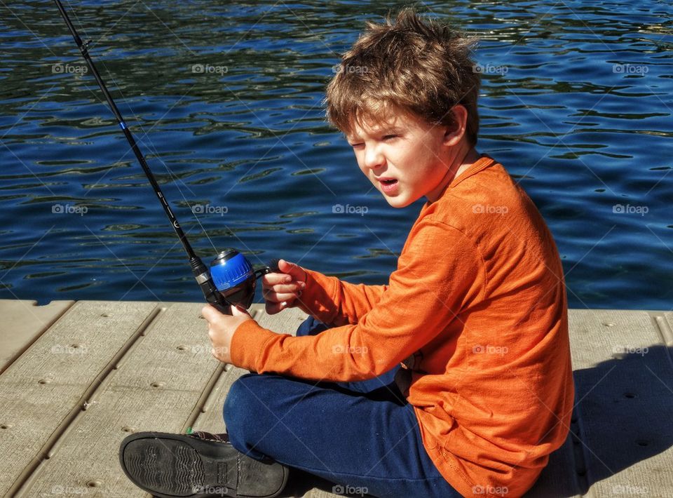 Young Man With A Fishing Pole. Boy Fishing In The Summertime
