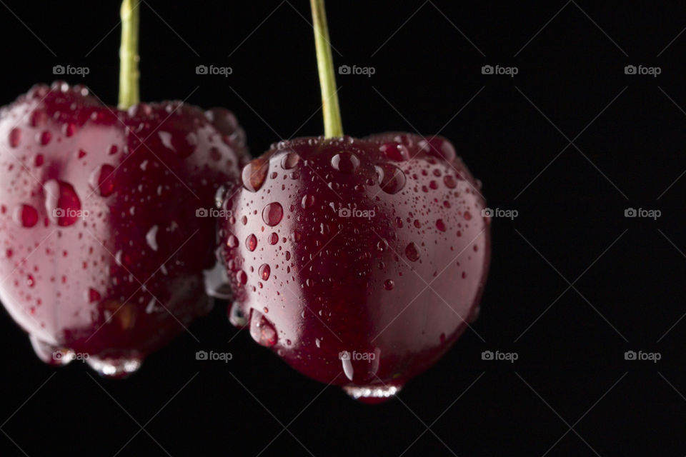two ripe sweet cherry covered with water drops