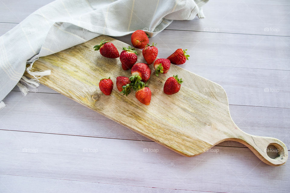 Strawberries on wooden board with tea towel- top view flat lay 