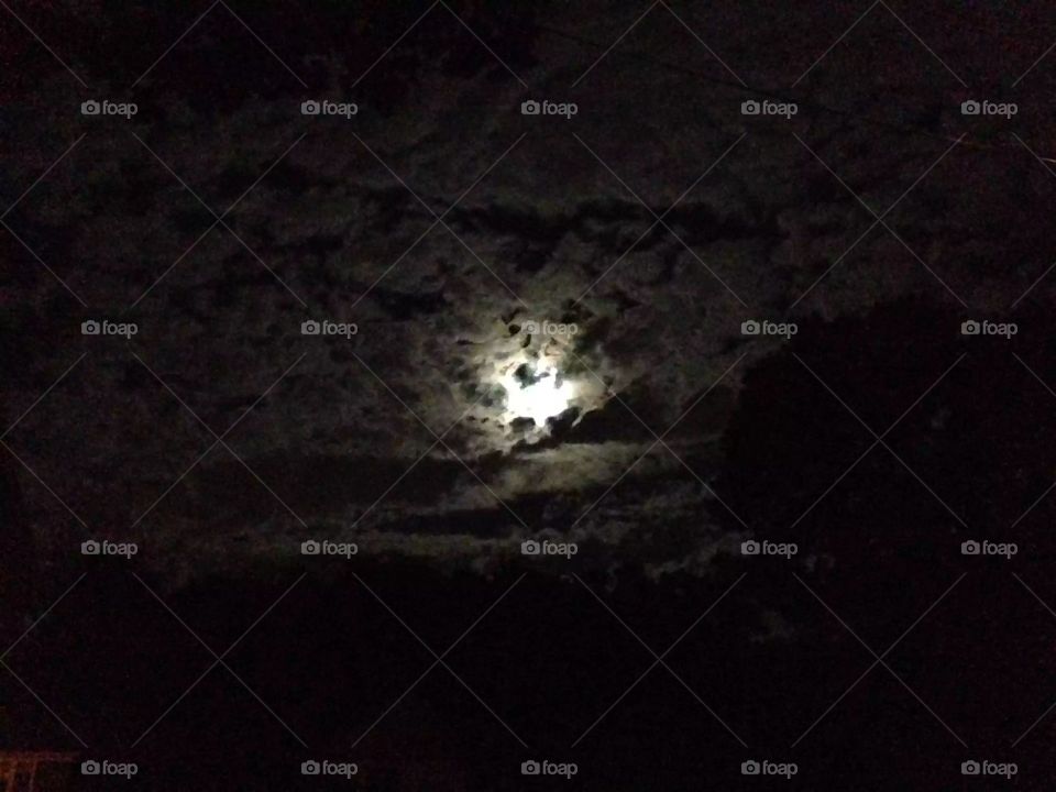 Eerily shaped clouds gathering around the full moon.