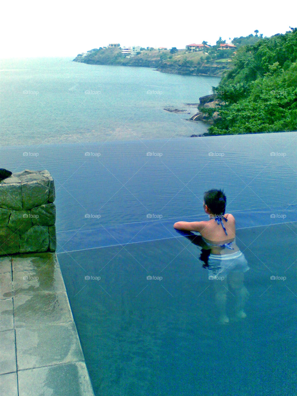 girl Swimming an an infinity pool with overlooking view