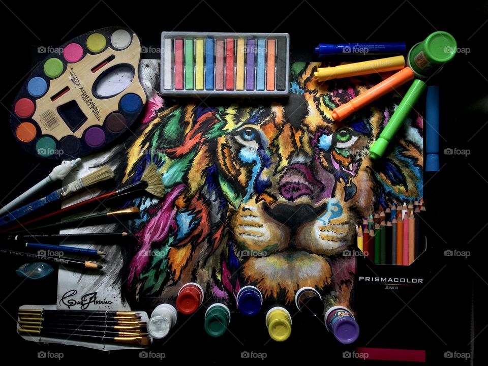 Foto plana multicolor, materiales para el dibujo, pinturas, colores prismacolor, marcadores, pinceles, tizas, con fondo negro.