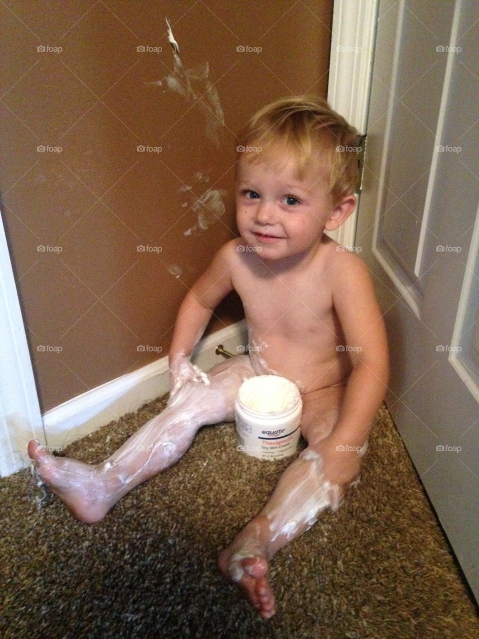 Child applying cream on body