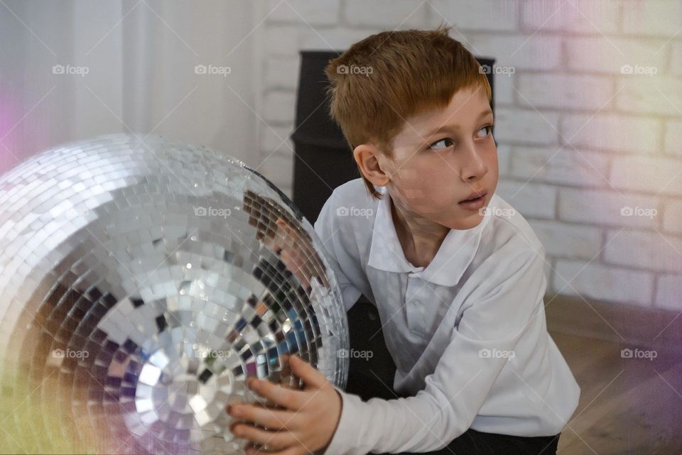 Close-up portrait of a child and a disco ball