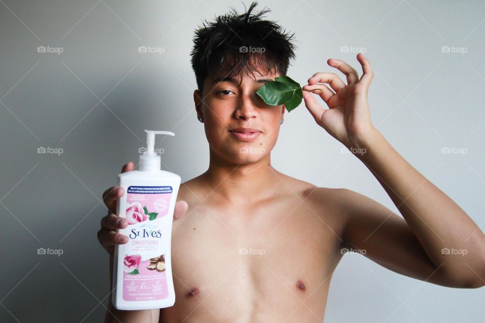 Smiling handsome teen boy with St.Ives skin product