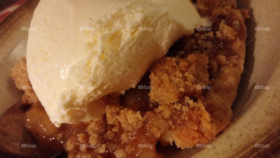 Homemade country goods. Hot crumbly Apple pie with cool soft vanilla bean ice cream to subtle the taste. 