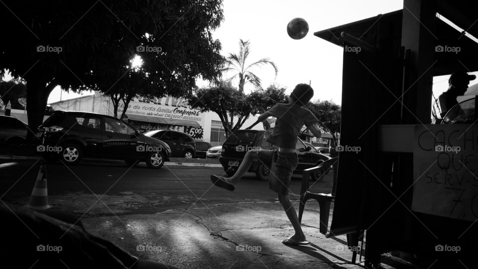 Menino brincando com uma bola.