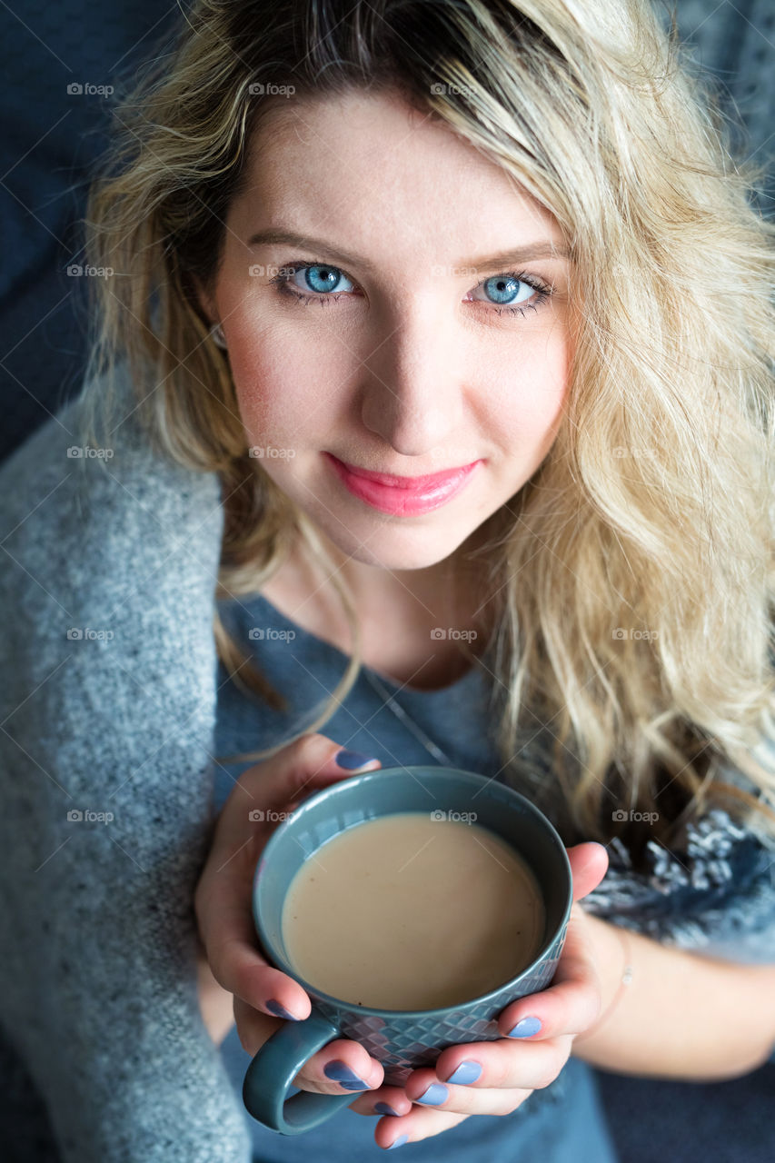 Portrait of blonde woman holding cup of coffee