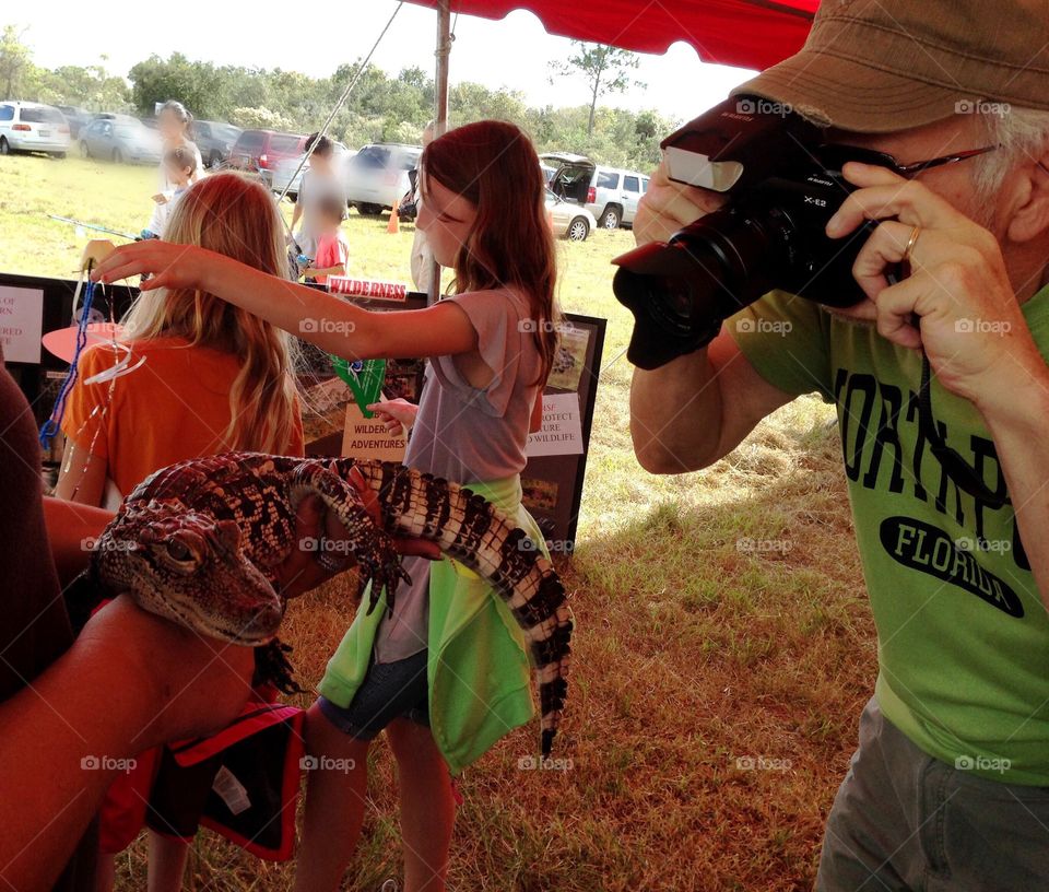 Baby alligator ready for his closeup by an active photographer.