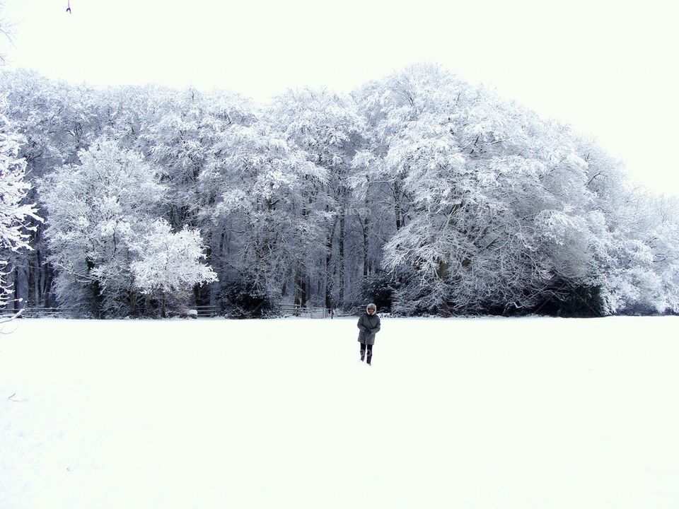 Woman walking in snowy landscape 