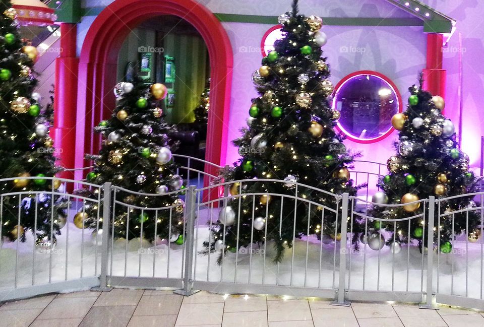 decorated Christmas trees in front of Santa headquarters holiday photo op display building in Oregon mall