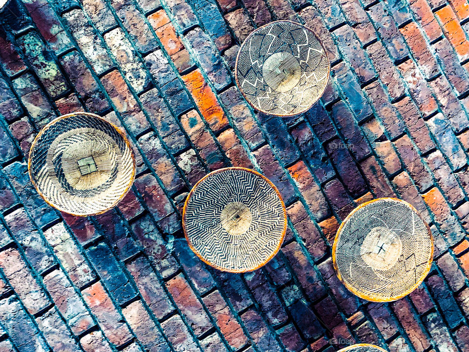 Finely coiled baskets hung on a brick as an ancient African theme on a brick wall in a restaurant. 