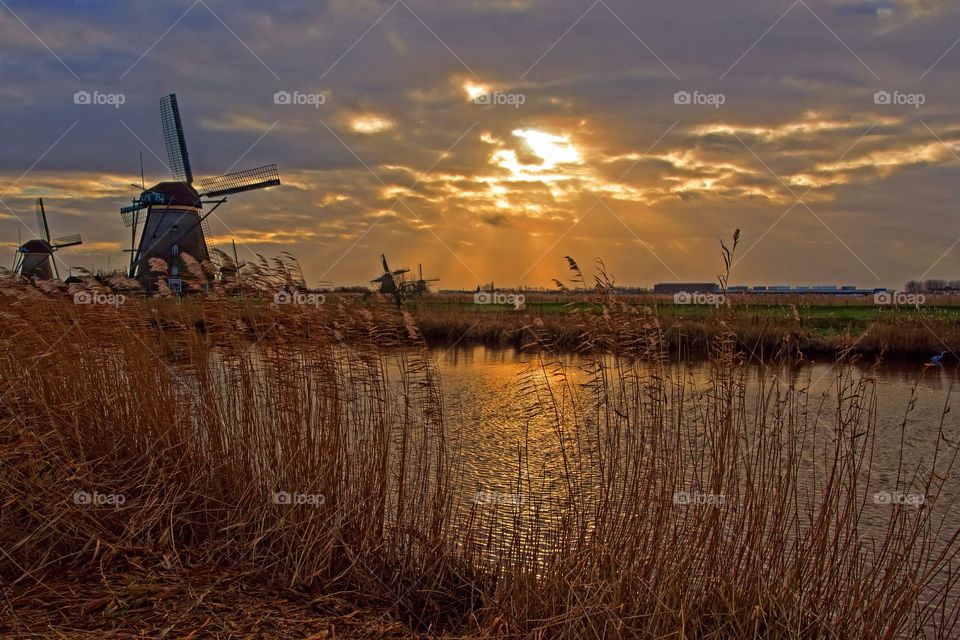 sunset, windmills, reflection in a chanal