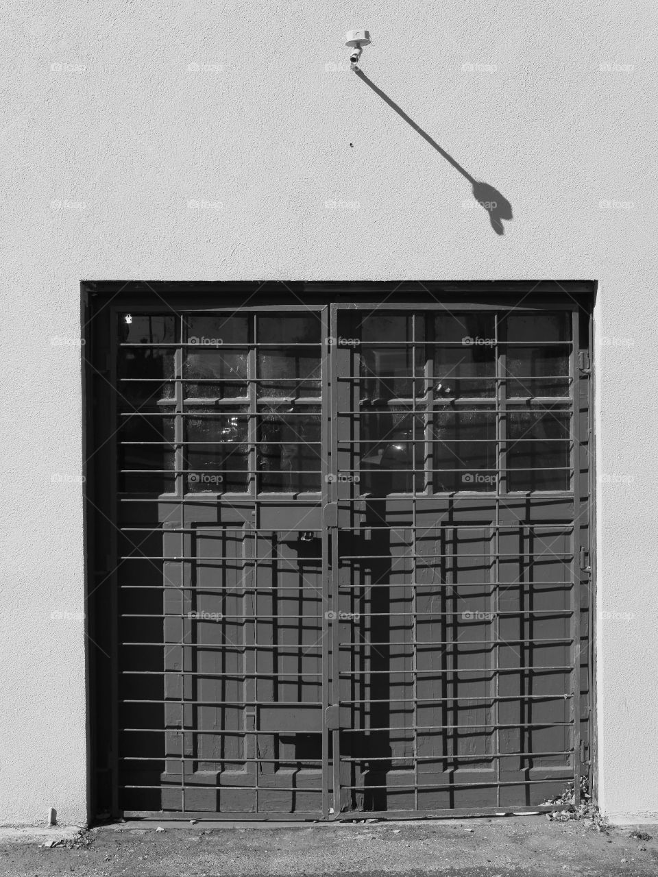 The side of an old concrete building in a city with doors on a sunny summer day. 