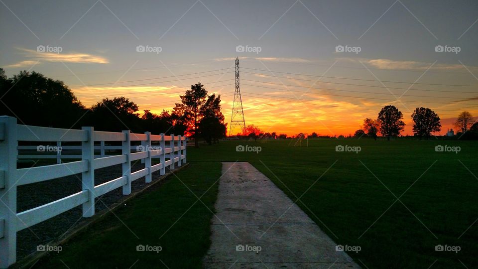 Sunset fence dusk sidewalk trees sky orange yellow Tower
