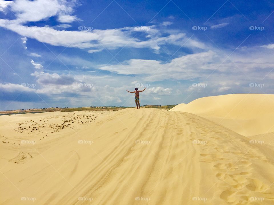 Man with open arms at the white sand dunes 