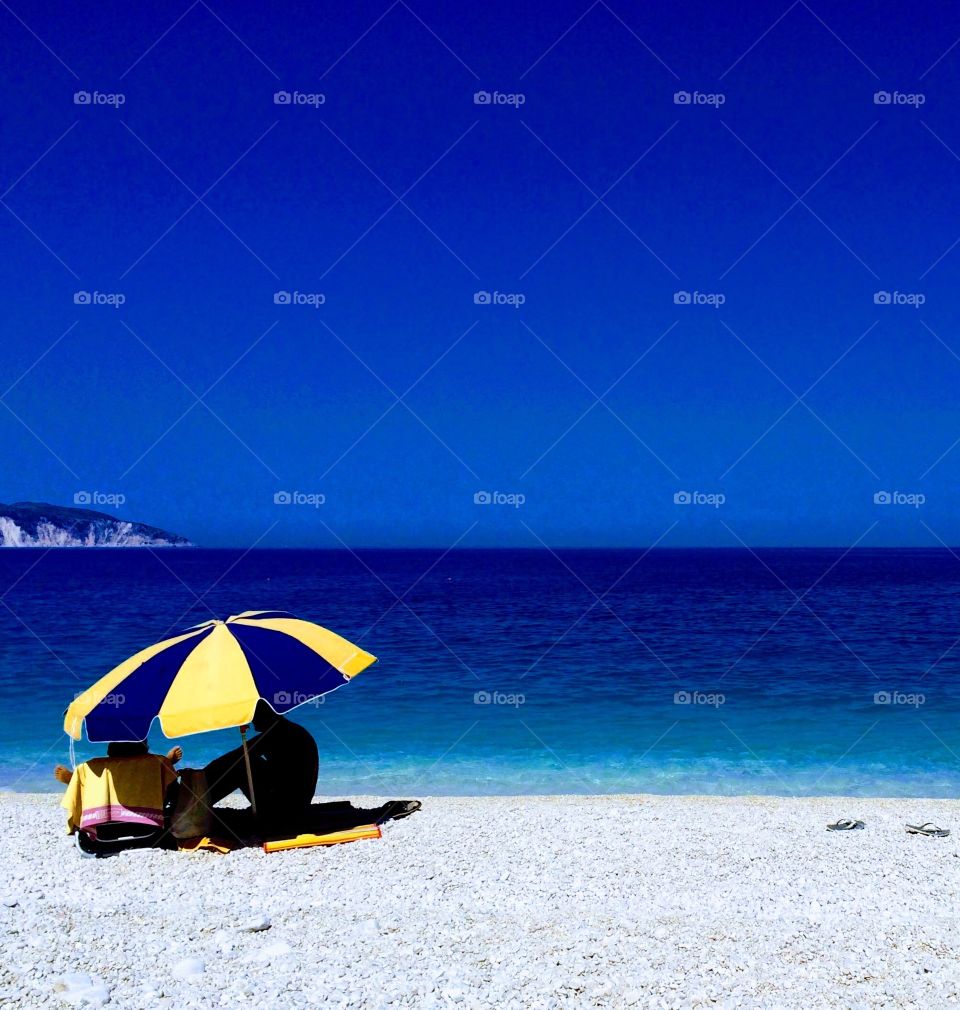 RED HOT BLUE SKY DAY ... seeking shade under a parasol ... I love the flip flops ... rhs of this photo 💙