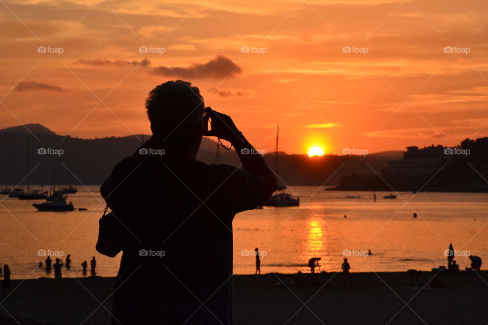 A person making a sunset photo