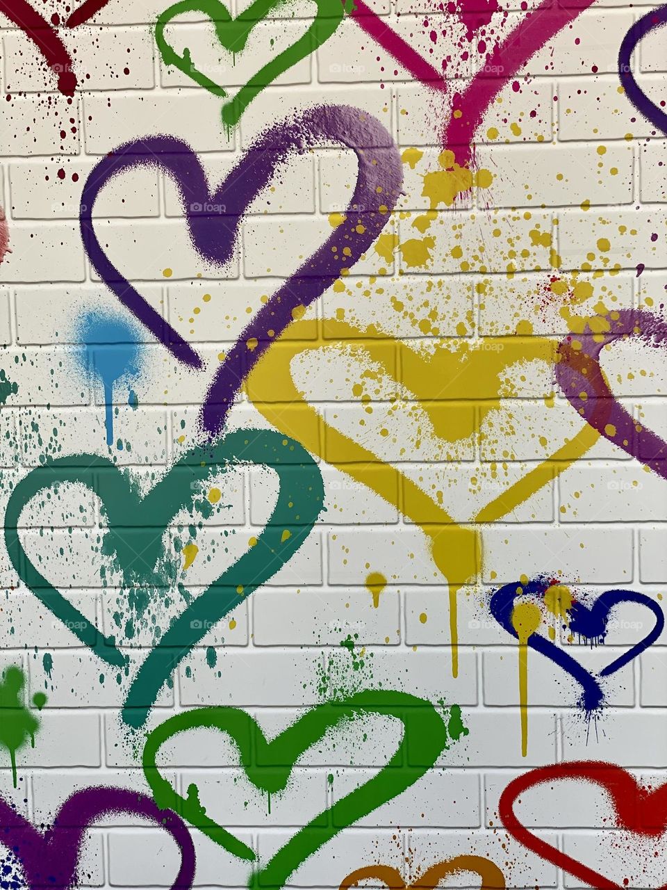 Hearts painted on a wall in a rainbow of colors