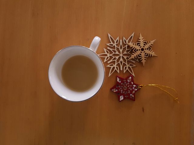 Warm beverage beside a few winter decorations.
