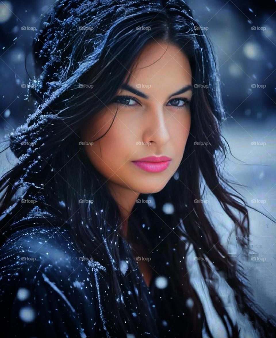 Selfie portrait of a woman in black.  There are snowflakes on the woman's hair.  It's snowing all around