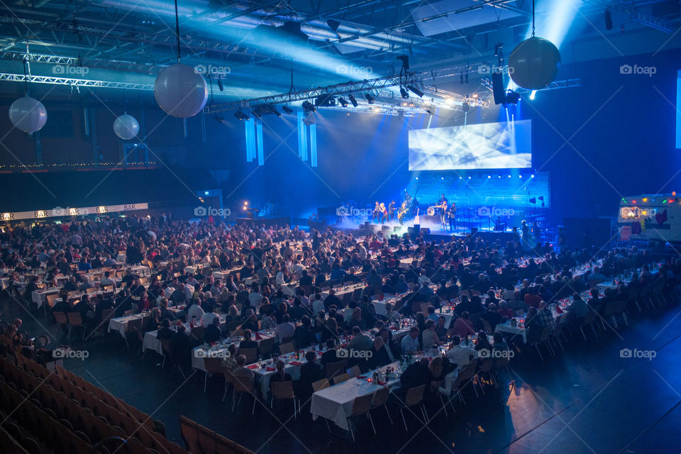 A large corporate event with live performers and various appearances in a large arena.