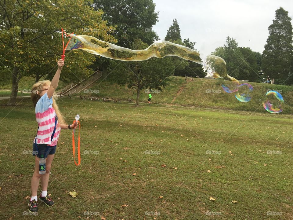 Girl making large bubbles 