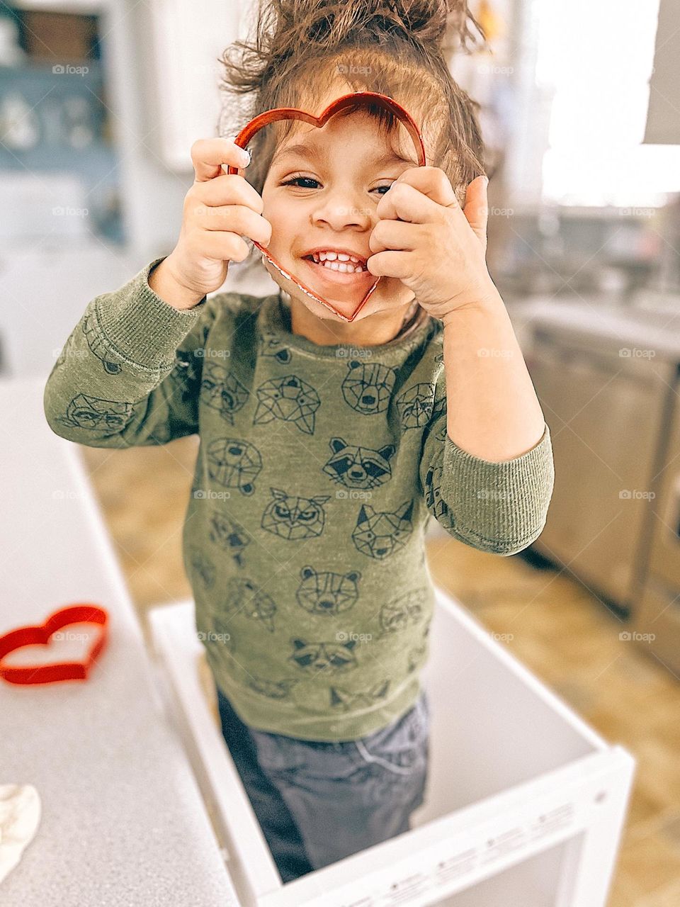 Portraits of toddlers, toddler girl being silly with cookie cutters, smartphone photography, smiling toddler makes cookies, toddler girl helps in the kitchen, fun with toddlers, cooking fun with toddlers 