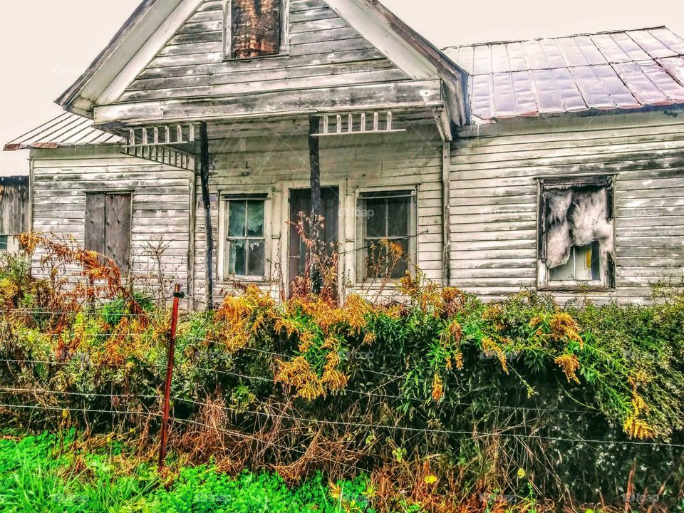 An abandoned, old, dilapidated house on a farm in the country.