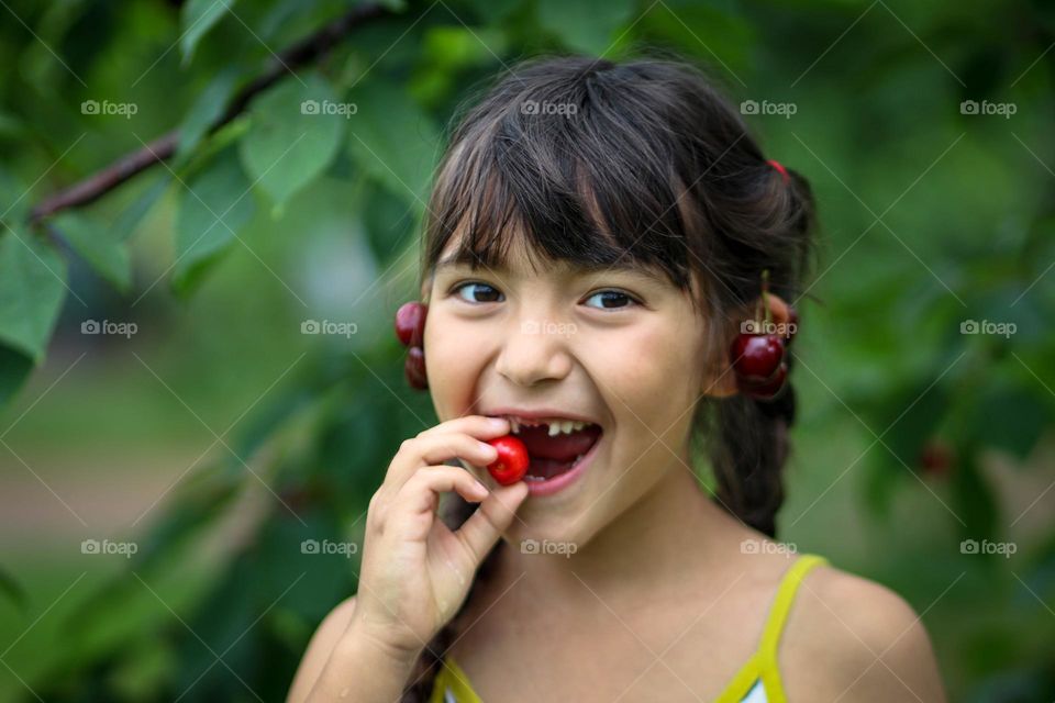 Portrait of a happy girl with cherries