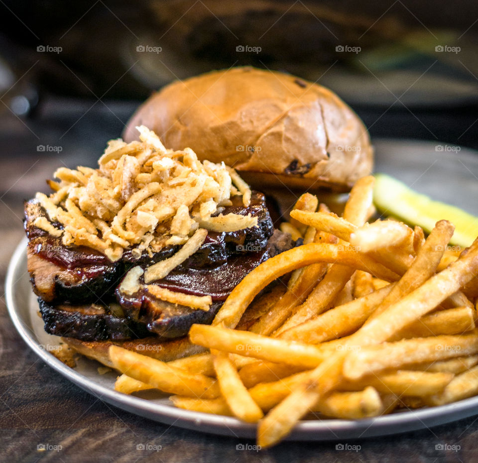 Beef brisket sandwich . Beef brisket sandwich with crispy onions and french fries