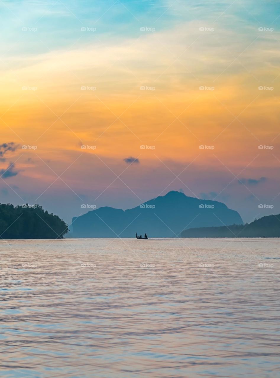 Beautiful Sunrise moment above silhouette of boat in sea